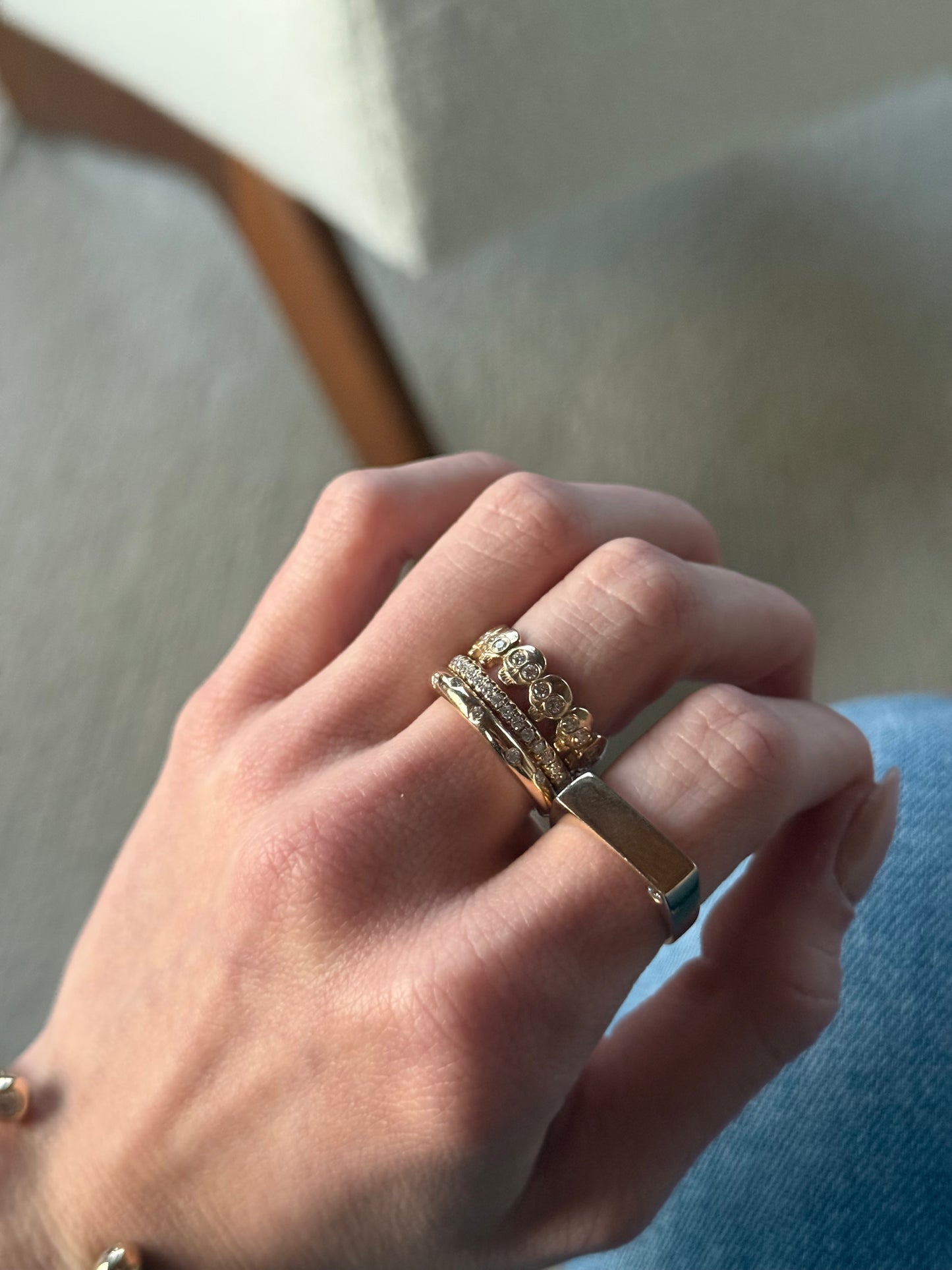 14k yellow gold skull ring stacked with J.Tyler bands on hand in natural light